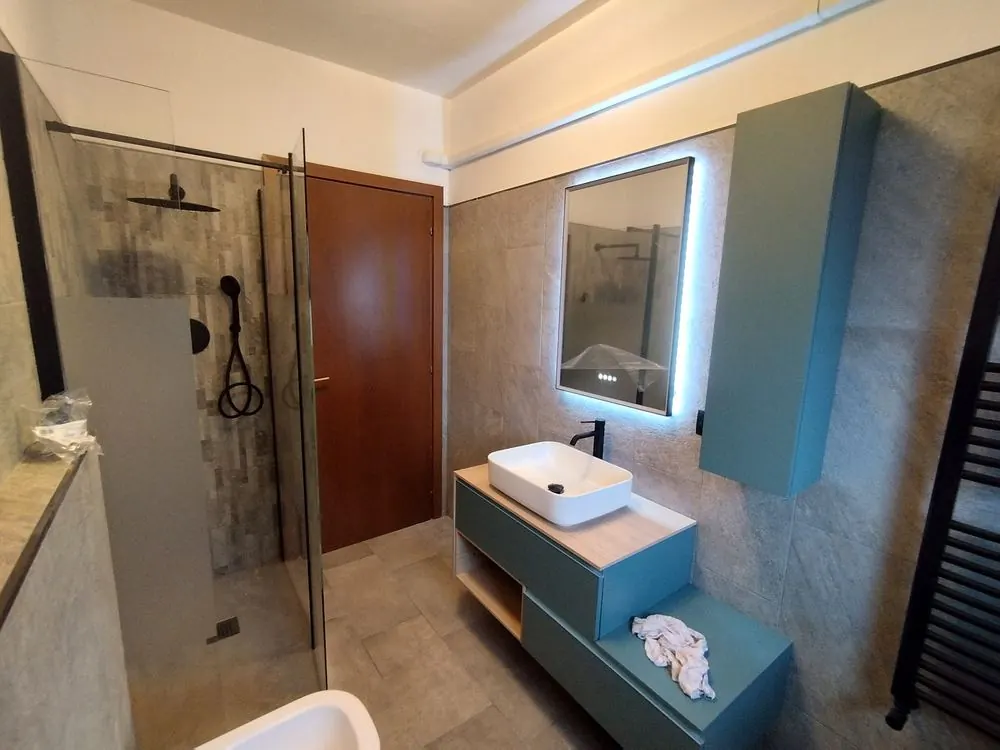 Bagno ultimato con doccia walk-in e lavabo sospeso