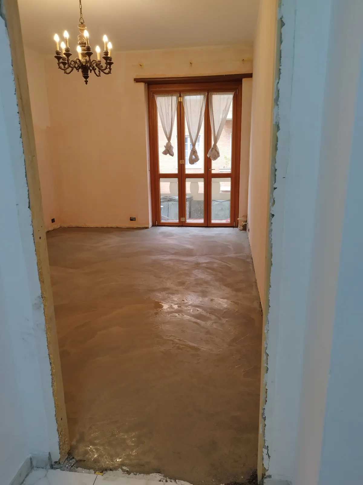 Autolivellante steso in sala, con il vecchio lampadario ancora al suo posto — Appartamento in Crocetta, Torino