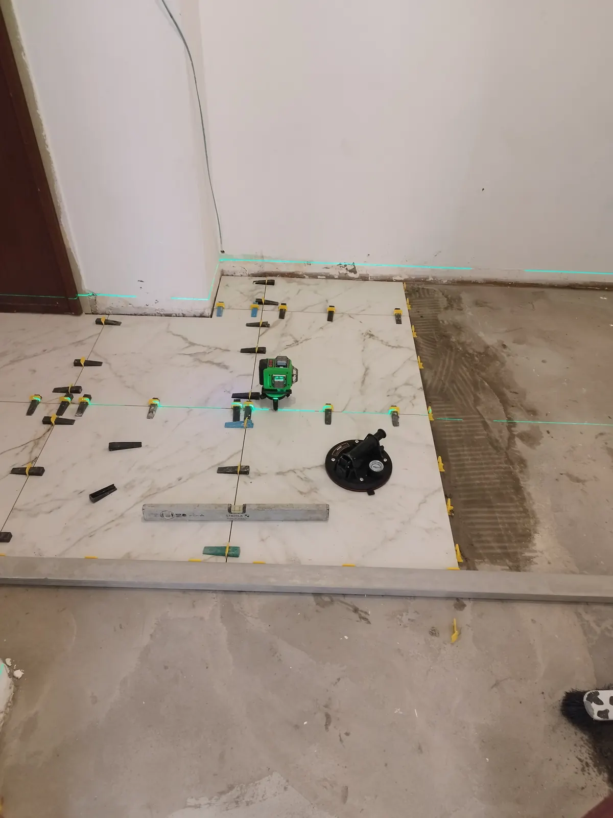 Avvio della posa Marazzi Calacatta 60×60 con sistema di livellamento — Appartamento in Crocetta, Torino