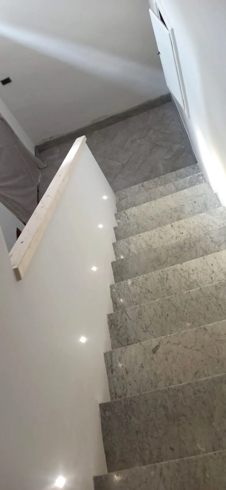 Scala in marmo ultimata con pianerottolo a spina di pesce
