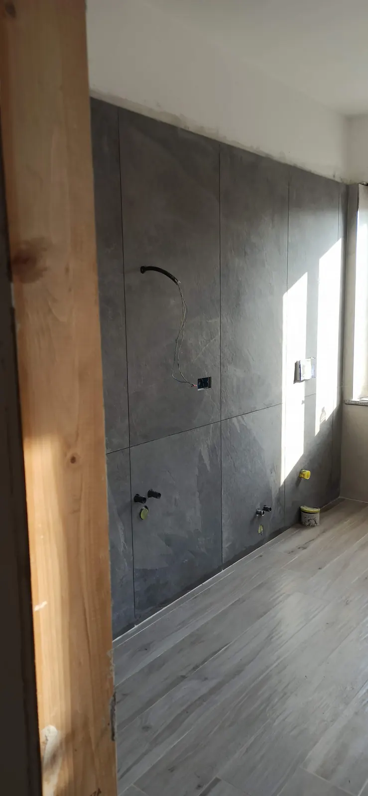 Rivestimento in grandi lastre con gli attacchi del doppio lavabo e del WC, prima del mobile — Villa in Corso Casale, Torino