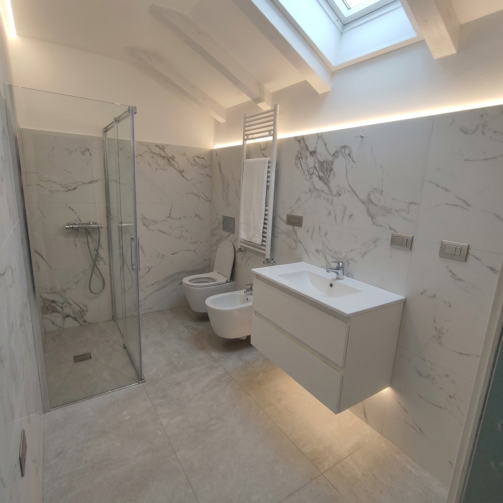 Bagno mansardato in marmo con illuminazione LED